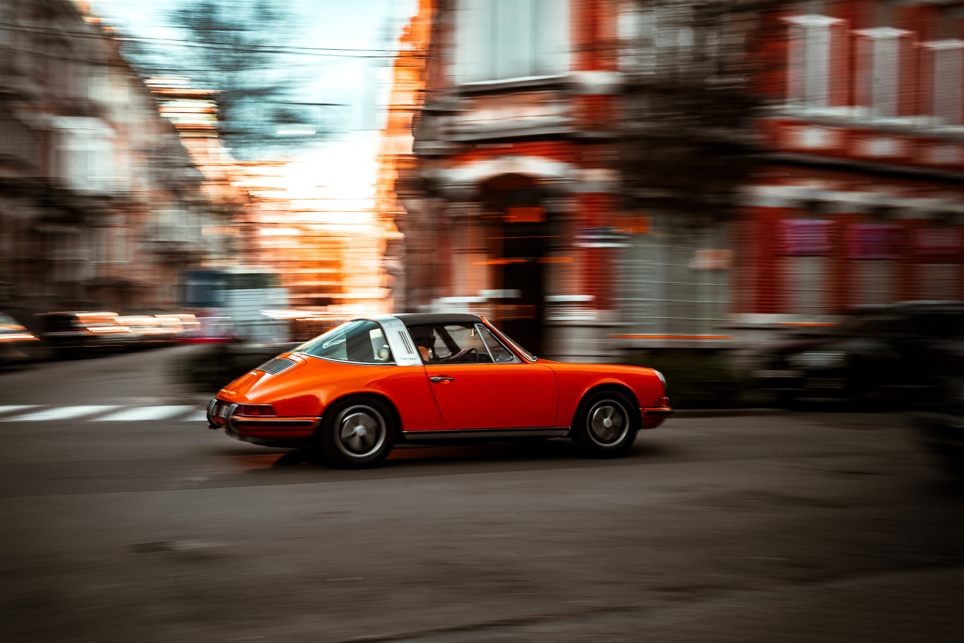 Panning shot of an orange Porsche Targa